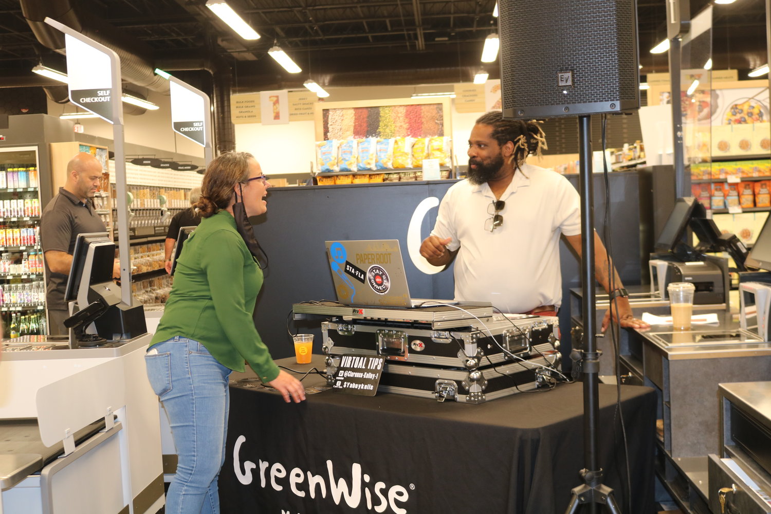 Store manager Leslie Anderson chats with DJ Clarence Kelly during the June 17 event.